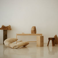 Natural wood tones with smooth and textured surfaces in a minimalist room setting. Earthy colors create a calming aesthetic.