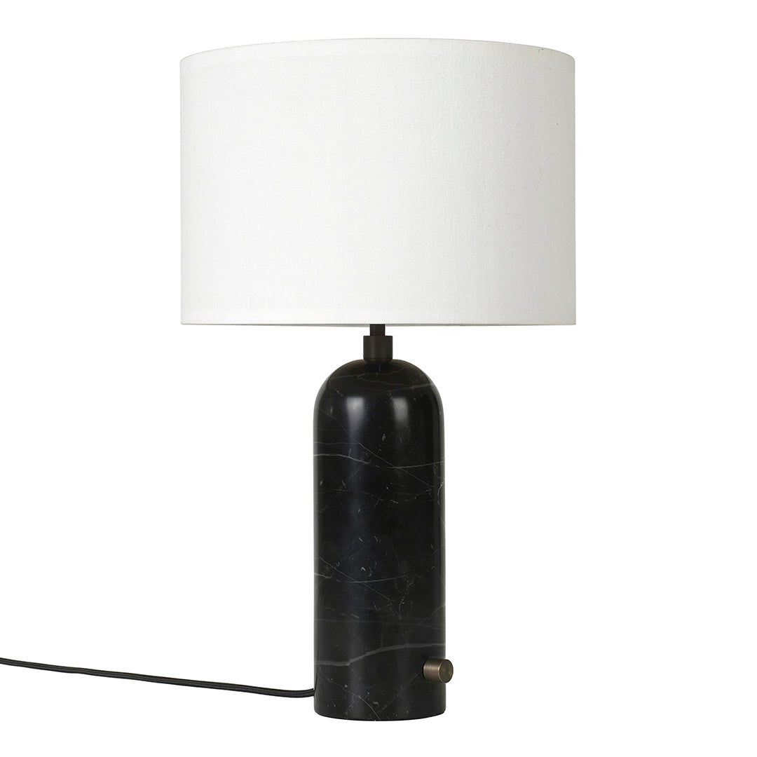 Black marble lamp base with a smooth, rounded design and a white drum shade for a modern touch.