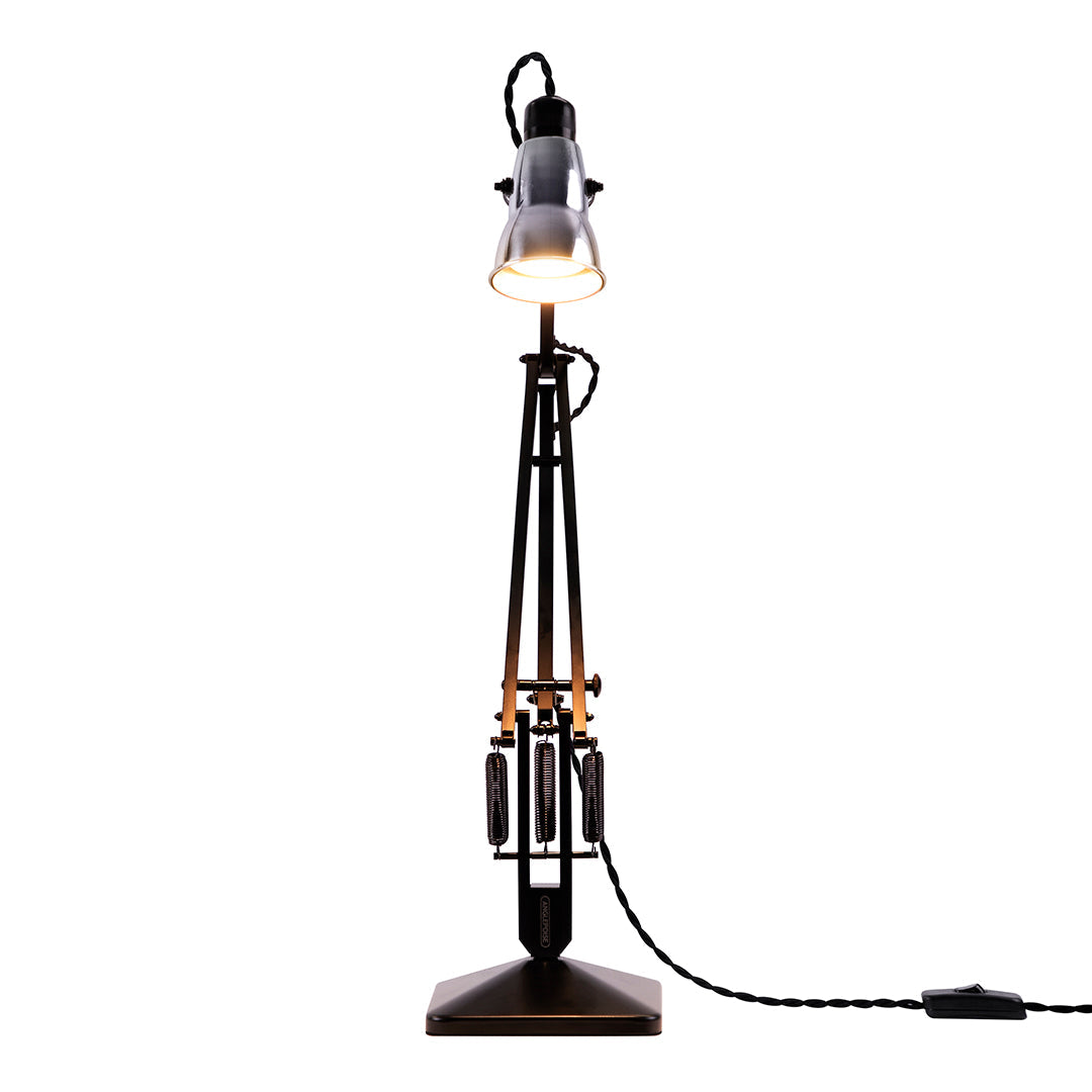 Industrial-style floor lamp with a sleek black base, gold accents, and a clear glass shade.