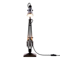 Industrial-style floor lamp with a sleek black base, gold accents, and a clear glass shade.