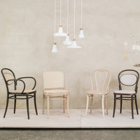 Set of four stylish chairs in black, beige, and brown against a textured gray backdrop. Modern design with simple lines.
