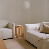 Neutral beige and soft cream furniture with light wood accent table, creating a calm, modern living space.