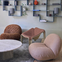 Textured brown and soft beige chairs with a pink accent table on a light gray rug in a stylish living room setting.
