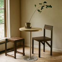 "Minimalist wooden table and chairs in natural tones, showcasing a light wood finish and dark stained accents."