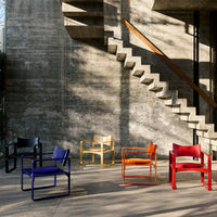 Vibrant chairs in purple, yellow, orange, red, and black showcased against a textured concrete backdrop.
