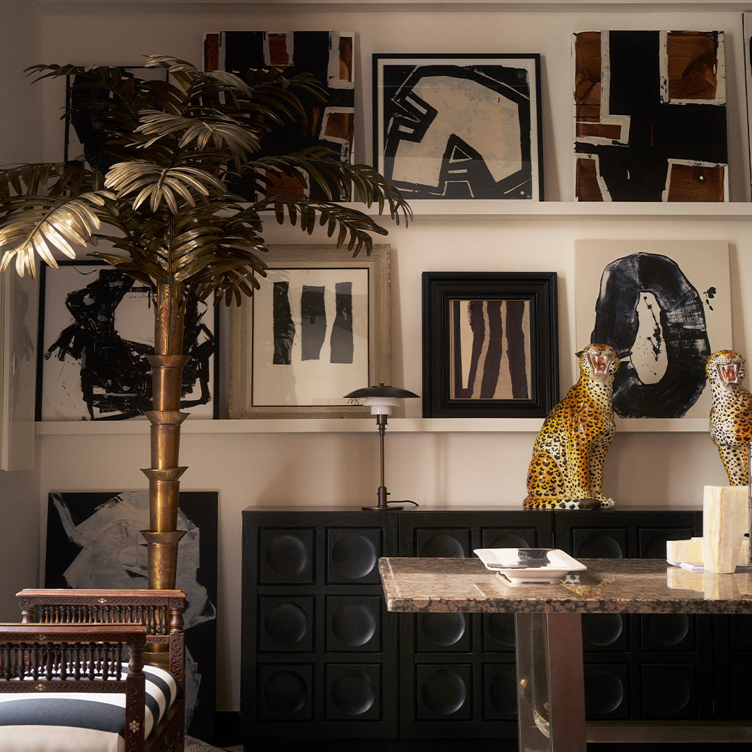 "Abstract black and white wall art with earthy tones and bold striped patterns, set in a stylish interior."