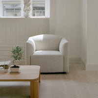 Light beige upholstered accent chair with soft, minimalistic design and a smooth texture. Ideal for modern interiors.