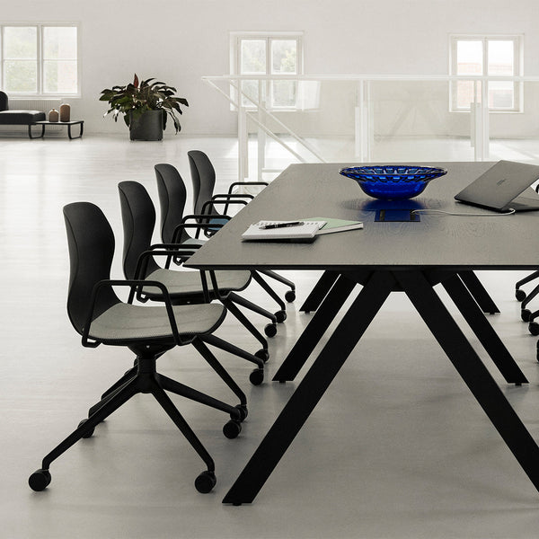 Modern office setup with a black table and chairs, featuring a blue bowl and sleek grey patterns. Clean, minimalist design.