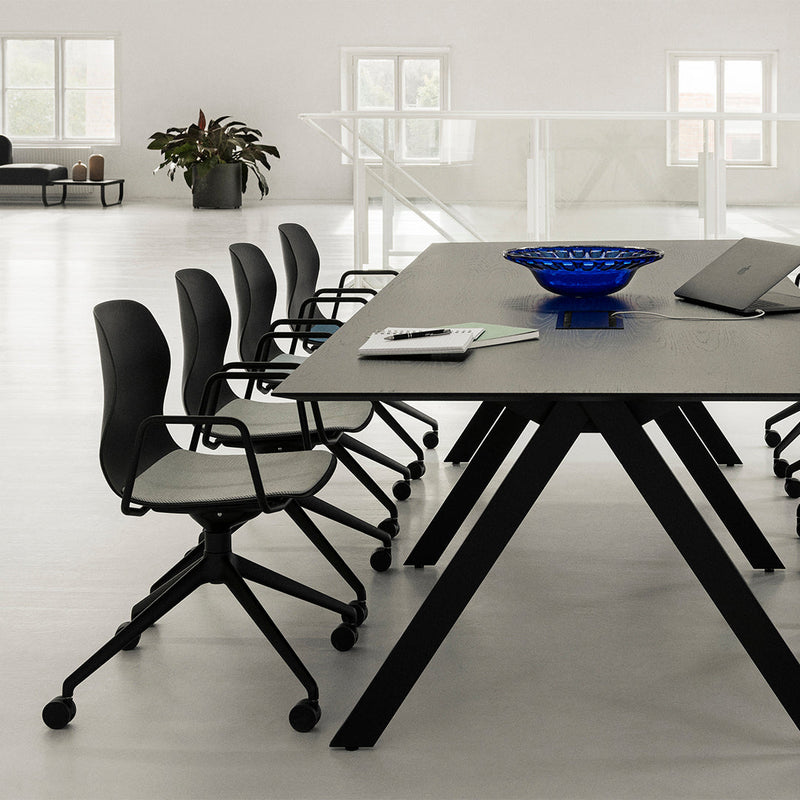 Modern office setup with a black table and chairs, featuring a blue bowl and sleek grey patterns. Clean, minimalist design.