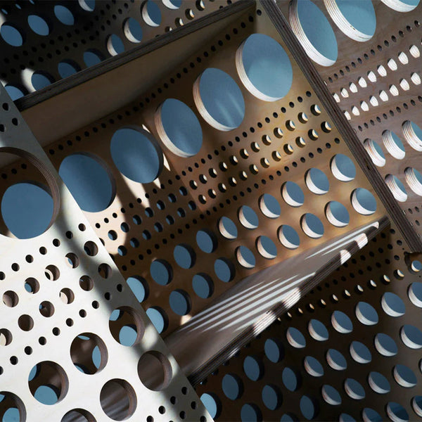 Light wood with blue circular cutouts and varying hole sizes, creating a modern and geometric pattern.