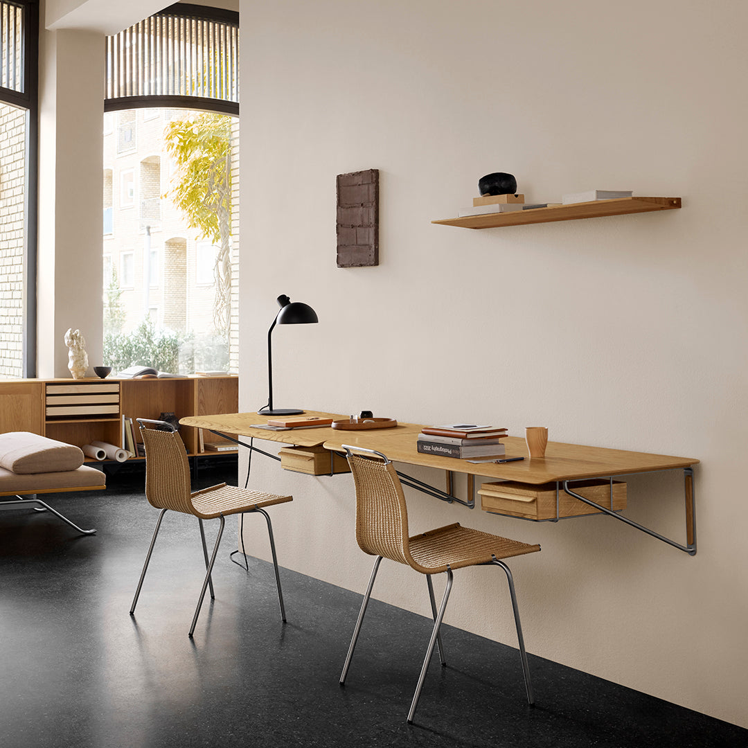 Light wood desk and chairs with sleek metal legs, featuring neutral wall color and minimalist décor for modern aesthetics.