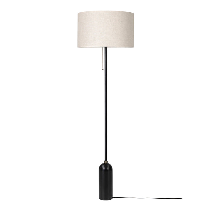 Black floor lamp with a cylindrical base and a beige fabric shade. Minimalist design with neutral colors.