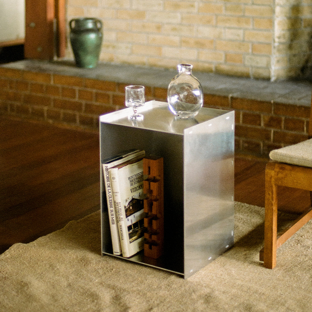 Silver metallic side table with sleek, modern design; minimalist style complements natural wood and woven textures.
