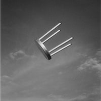 Black and white image of a minimalist chair, featuring a smooth, circular seat and sleek metal legs.