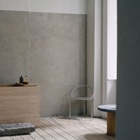"Minimalist interior showcasing soft gray walls, light wood furniture, and earthy stone accents, enhancing contemporary design."