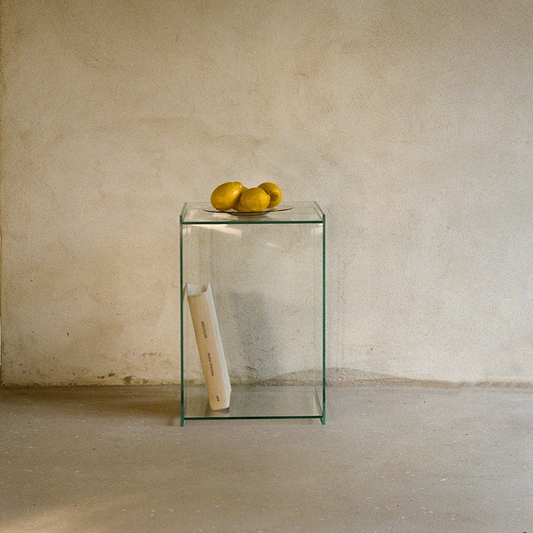 Clear glass side table showcasing minimalist design with smooth surfaces, perfect for modern interiors.