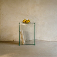 Clear glass side table showcasing minimalist design with smooth surfaces, perfect for modern interiors.