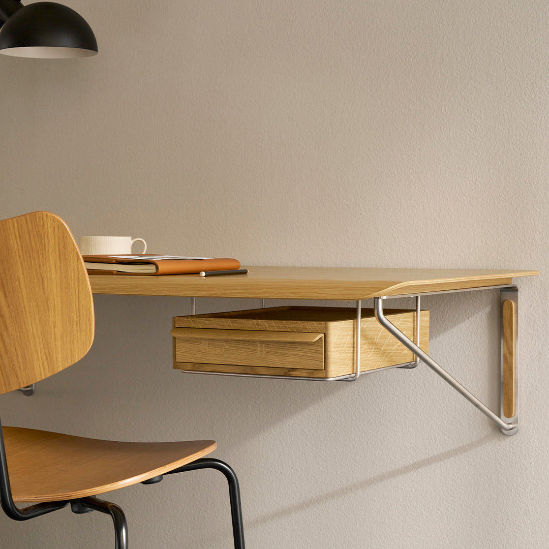 Wooden wall-mounted desk with natural finish, featuring a sleek drawer and minimalist design against a neutral background.