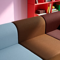Multicolored sofa with soft textures: light blue, rich brown, and deep burgundy sections against a pastel background.