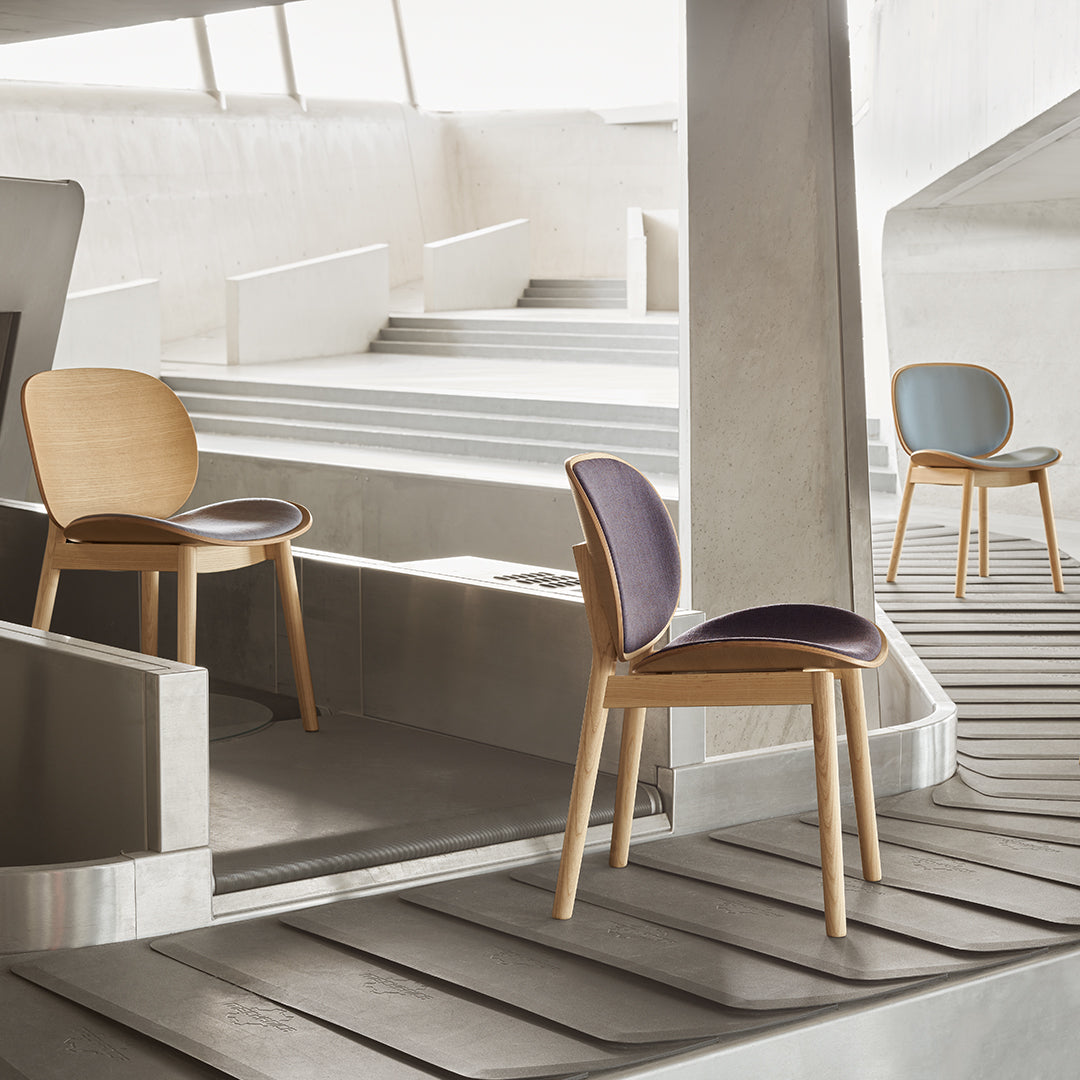 Modern chairs in natural wood, featuring soft gray, rich purple, and elegant curved lines on a minimalist setting.