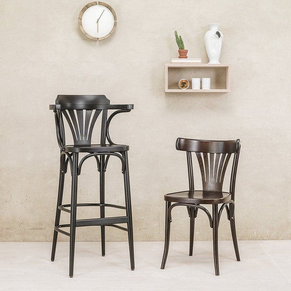 "Elegant black wooden bar stool and chair with curved backrest design, set against a neutral beige background."