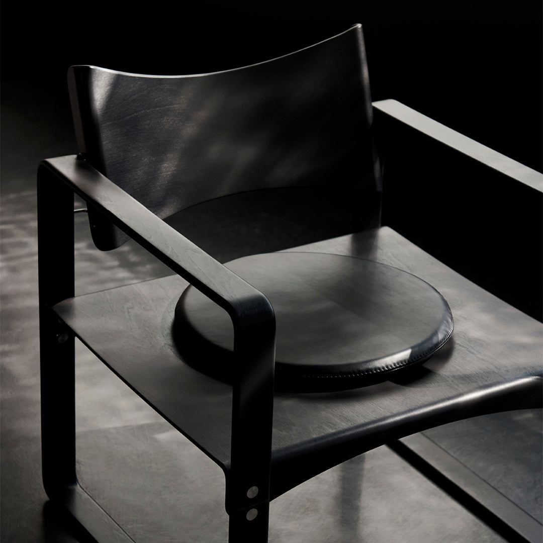 Stylish black chair featuring smooth surfaces and minimalist design perfect for modern interiors.