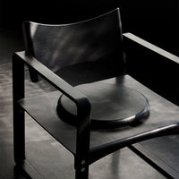 Stylish black chair featuring smooth surfaces and minimalist design perfect for modern interiors.