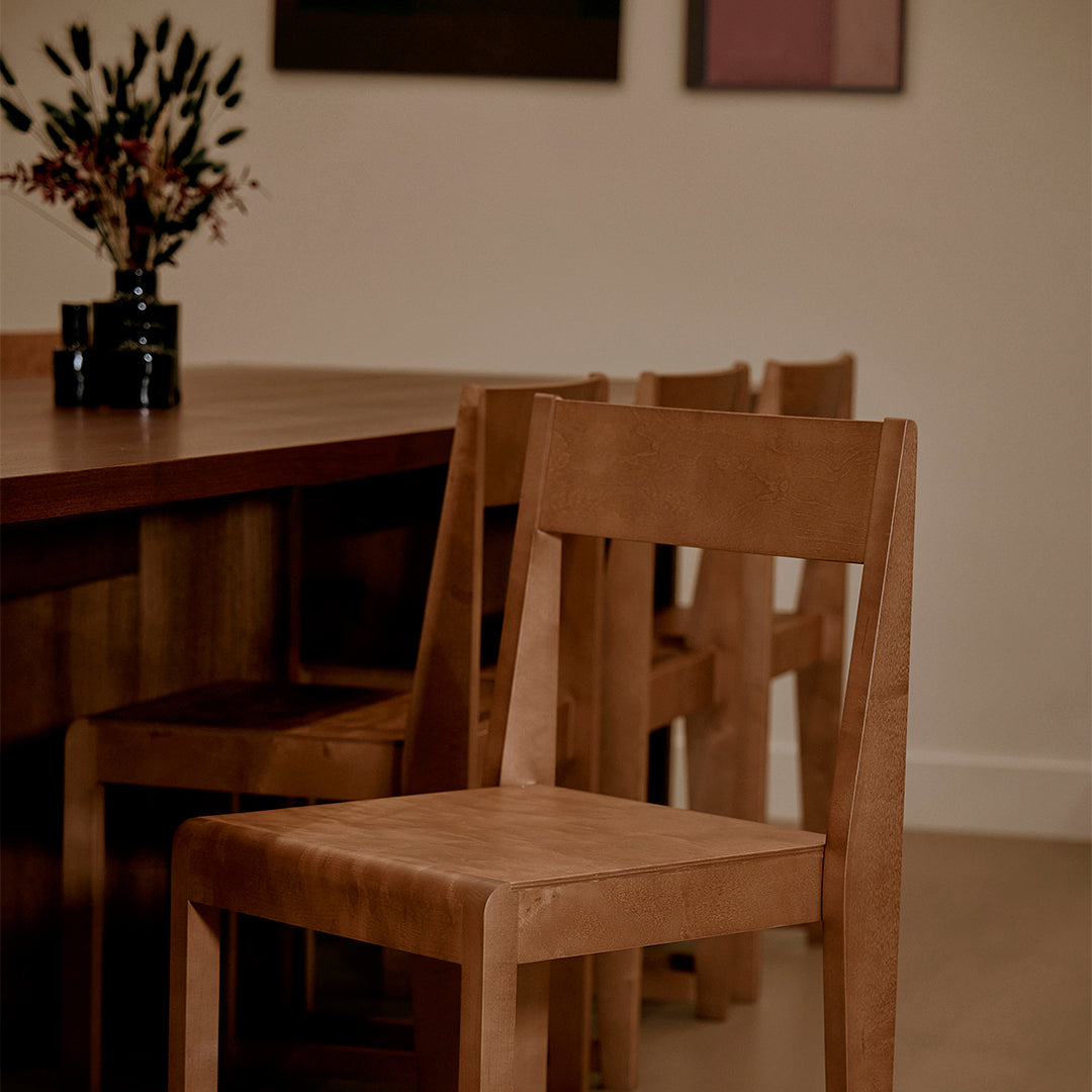 Natural wood chairs in warm tones, featuring a minimalist design and smooth, simple patterns.