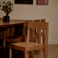 Natural wood chairs in warm tones, featuring a minimalist design and smooth, simple patterns.