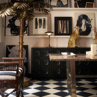 Stylish black and white checkered floor with vibrant gold and leopard-patterned décor, enhancing modern interior design.