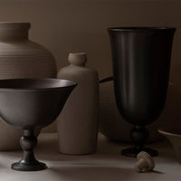 "Elegant dark and light pottery with smooth and textured finishes, showcasing a minimalist color palette."