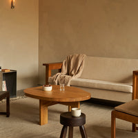 Cozy living room with beige sofa, light wood furniture, soft brown throw, and neutral-toned decor for a warm aesthetic.