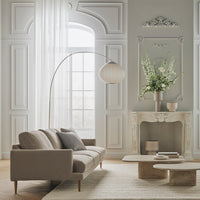 Beige sofa with light gray walls, elegant white curtains, and soft neutral decor, featuring subtle textures and patterns.