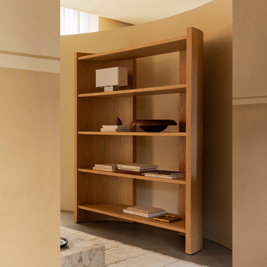 Curved wooden bookshelf in warm natural tones with a sleek and modern design, featuring multiple open shelves.