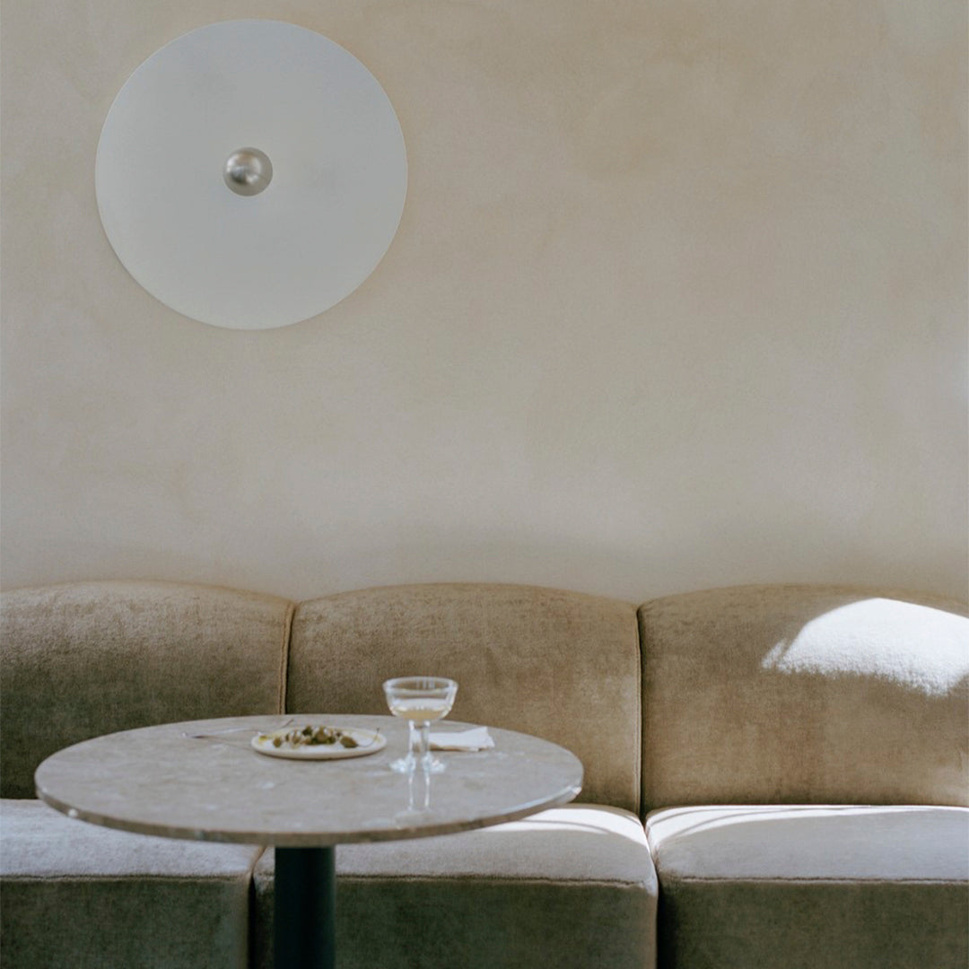 Beige velvet sofa with curved edges, light marble table, and soft wall textures complement the minimalist design.