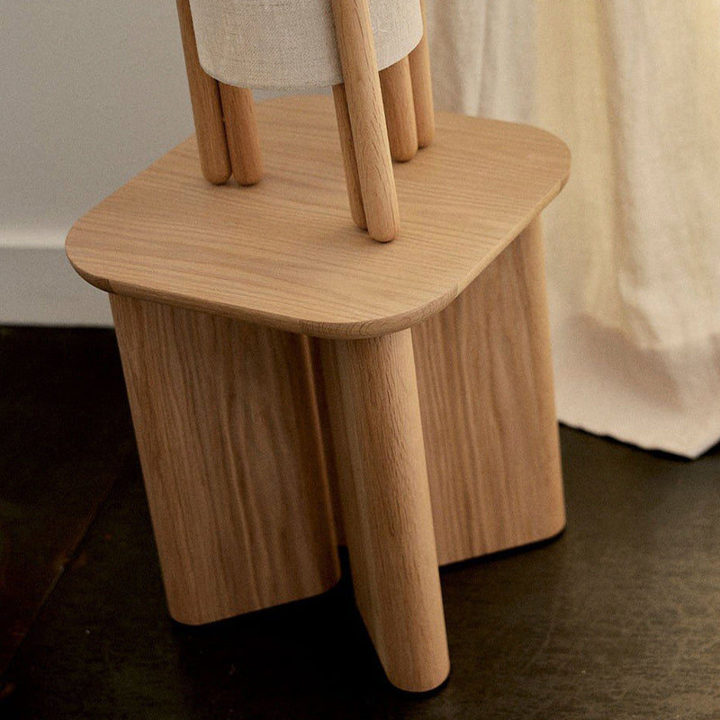Natural wood grain finish with light beige accents on a modern, geometric stool design.