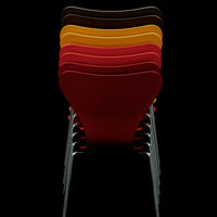 Stacked chairs in vibrant colors: red, yellow, orange, brown, showcasing a sleek design against a dark background.