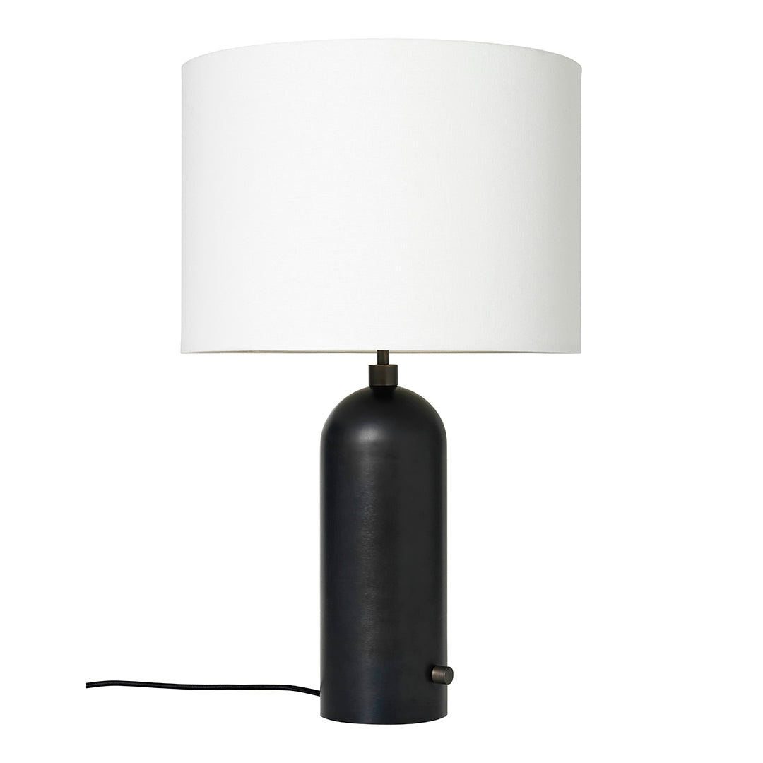 Modern black table lamp with a smooth round base and a simple white cylindrical shade.