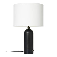 Modern black table lamp with a smooth round base and a simple white cylindrical shade.