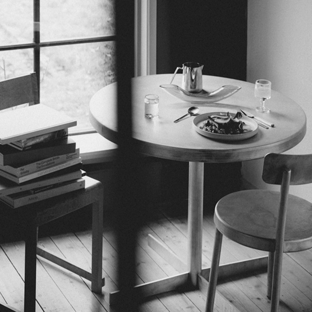 "Round wooden table with gray and white tones, featuring a minimalistic design and soft, neutral color palette."