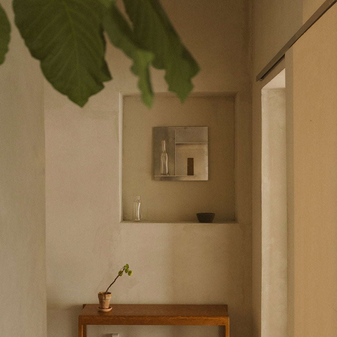 "Neutral beige walls with subtle texture, complemented by warm wooden accents and greenery for a serene ambiance."