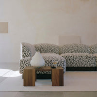 Leopard print fabric sofa in black and white, paired with a wooden coffee table and minimalist decor.