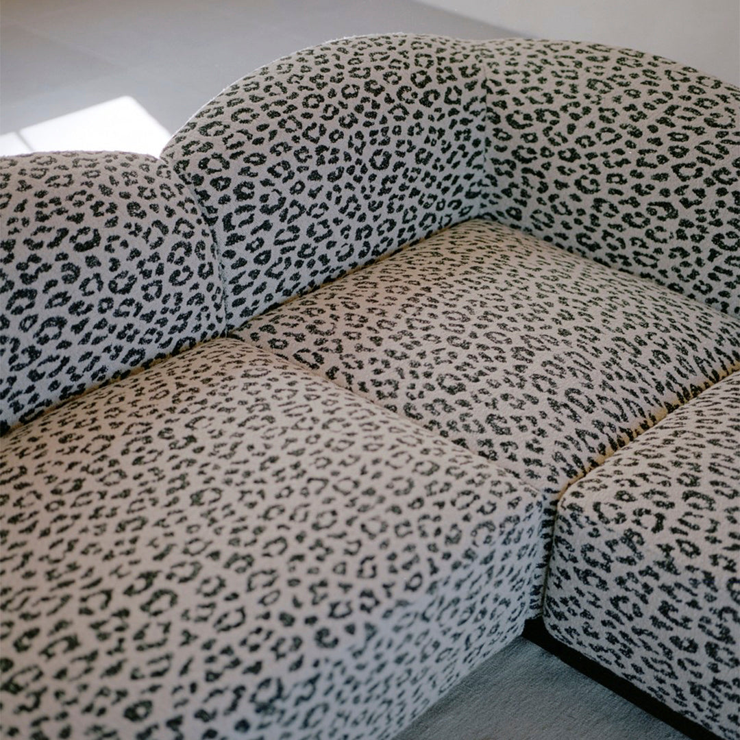 Leopard print sofa with black and beige colors, featuring a stylish curved design and plush upholstery.