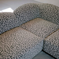 Leopard print sofa with black and beige colors, featuring a stylish curved design and plush upholstery.
