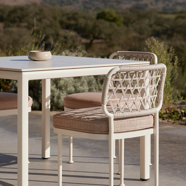"Elegant beige dining set with geometric woven chair patterns and a sleek white tabletop."