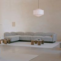Luxe sectional sofa in soft white with abstract black patterns, complemented by natural wooden accents.