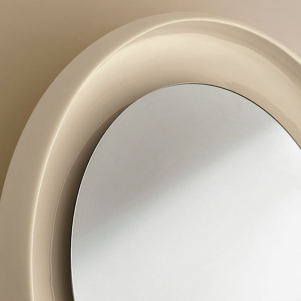 Elegant beige circular mirror with smooth glossy finish and reflective surface, perfect for modern decor.