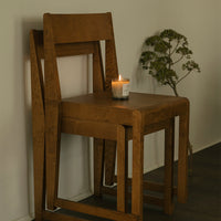"Stacked wooden chair in warm brown tones, featuring a smooth finish and minimalist design."