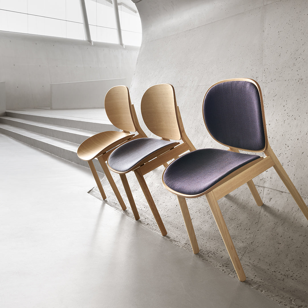 Set of three sleek chairs featuring a natural wood frame and deep navy upholstered seats, perfect for modern interiors.