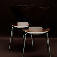 Two modern chairs in rich brown with a sleek glossy finish, featuring minimalist design and silver metal legs.
